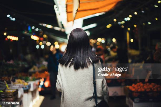 young woman shopping for fresh fruits and local produces in a local fruit market - food market stock-fotos und bilder