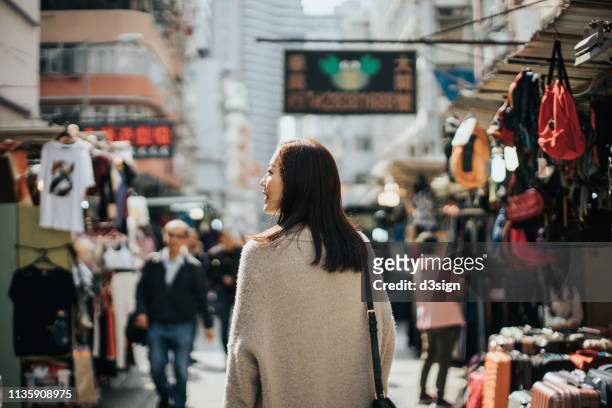 young woman exploring and walking through local market stalls in hong kong - travel market asia stock-fotos und bilder