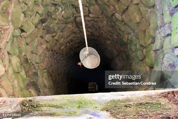 deep water well in the village, inside, rural in transylvania, romania. - waterput stockfoto's en -beelden