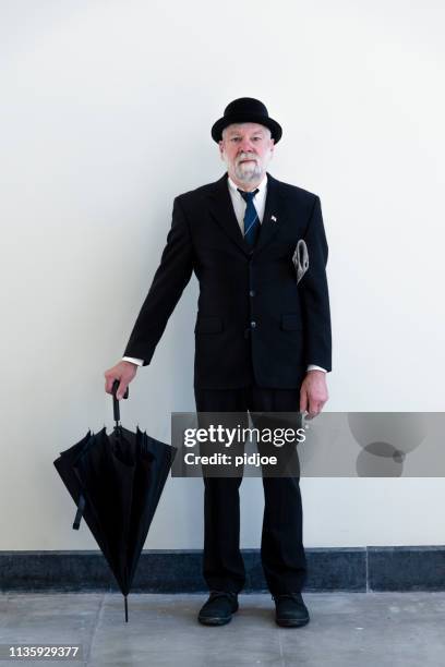 englishman in bowler hat and black umbrella. - bowler hat stock pictures, royalty-free photos & images