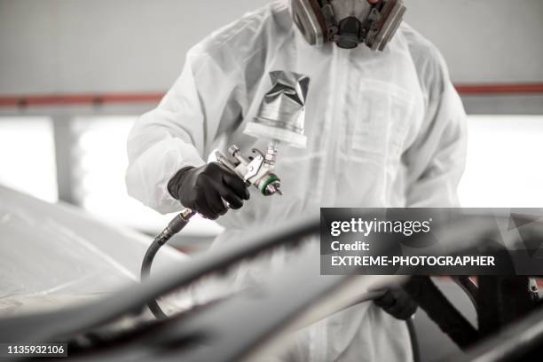 painting technician applying paint to a car part with a spray gun in a car body shop - spray painting car stock pictures, royalty-free photos & images