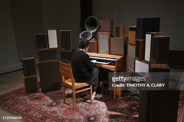 Woman tries out "Janet Cardiff and George Bures Miller, The Poetry Machine, 2017" an interactive audio/mixed-media installation including organ,...