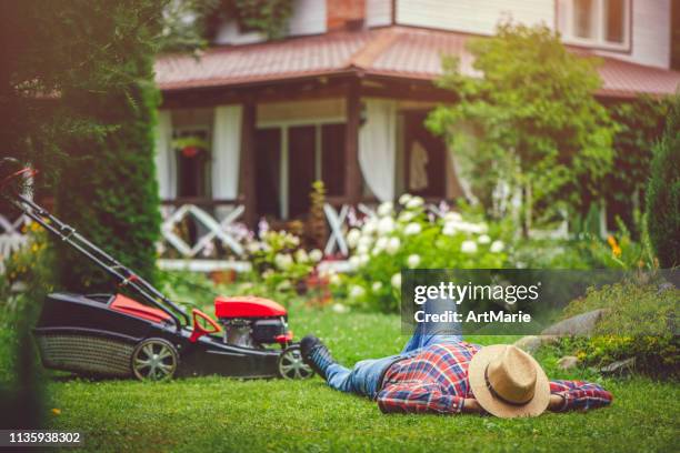 man using a lawn mower in his back yard - electric mower stock pictures, royalty-free photos & images