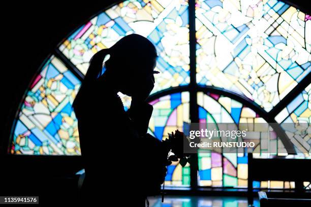 silhouette woman crying against stained glass - funeral bildbanksfoton och bilder