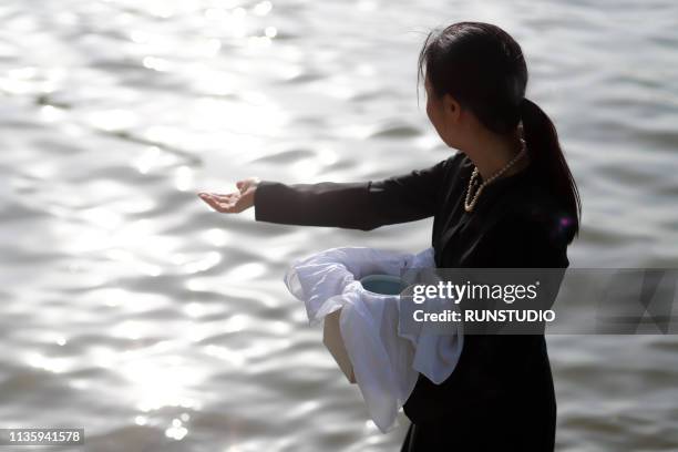 woman with urn spreading ashes - ashes stock pictures, royalty-free photos & images