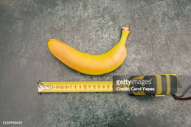 measure tape and banana.size matters - penis humour stock pictures, royalty-free photos & images