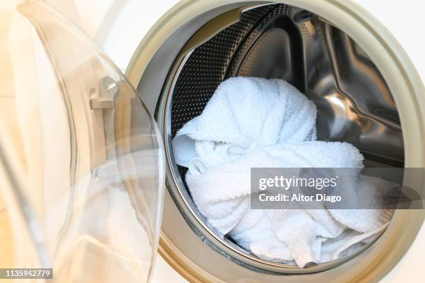 washing machine with some laundry inside. - towel ストックフォトと画像