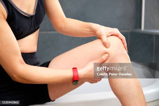 massaging pain in knee after exercise - female muscle calves stock pictures, royalty-free photos & images