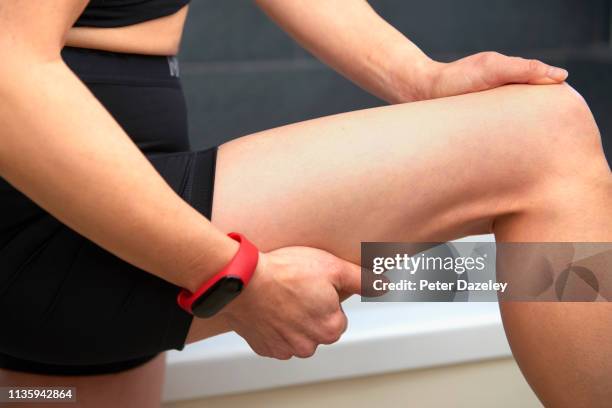 massaging pain in leg after exercise - thigh human leg imagens e fotografias de stock
