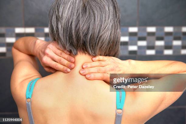 woman rubbing back of neck - young woman gray hair stock pictures, royalty-free photos & images