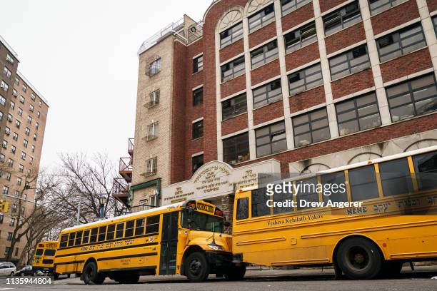School buses line up outside the Yeshiva Kehilath Yakov School in the South Williamsburg neighborhood, April 9, 2019 in the Brooklyn borough of New...