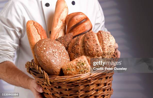 baker carrying basket of freshly baked bread - ciabatta stock-fotos und bilder