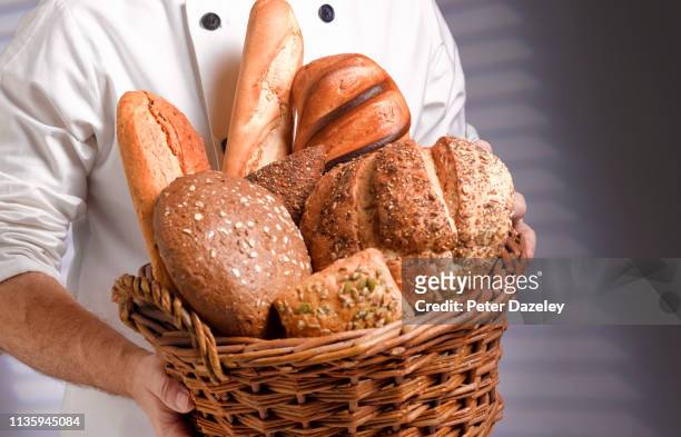 baker carrying basket of freshly baked bread - pasteleria fotografías e imágenes de stock