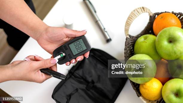 young woman taking blood sugar test - needs improvement stock pictures, royalty-free photos & images