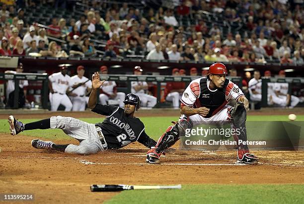 Dexter Fowler of the Colorado Rockies safely slides in to score a run past catcher Henry Blanco of the Arizona Diamondbacks during the fifth inning...