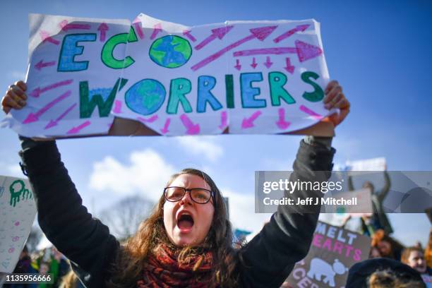 School children hold placards and shout slogans as they participate in a protest outside the Scottish Parliament on March 15, 2019 in Edinburgh,...