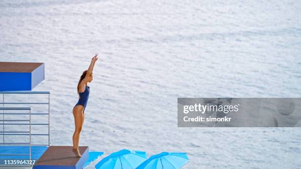 young woman standing on diving board - woman diving board stock pictures, royalty-free photos & images