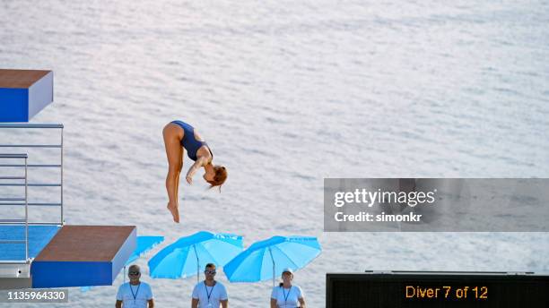 female diver diving into swimming pool - judgement look stock pictures, royalty-free photos & images