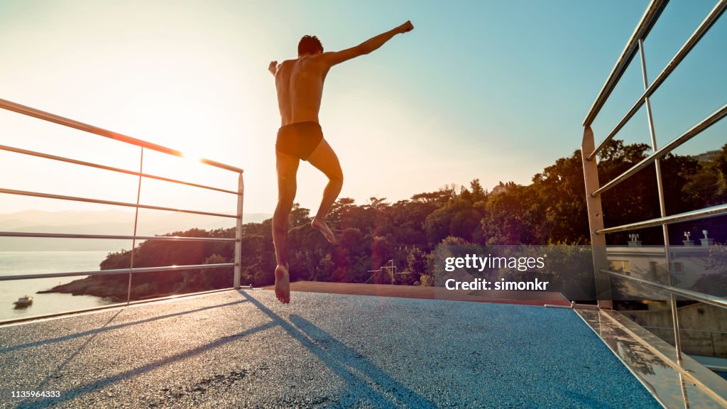 Young man diving into swimming pool