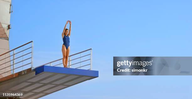 giovane donna in piedi sul trampolino - piattaforma dei trampolini foto e immagini stock