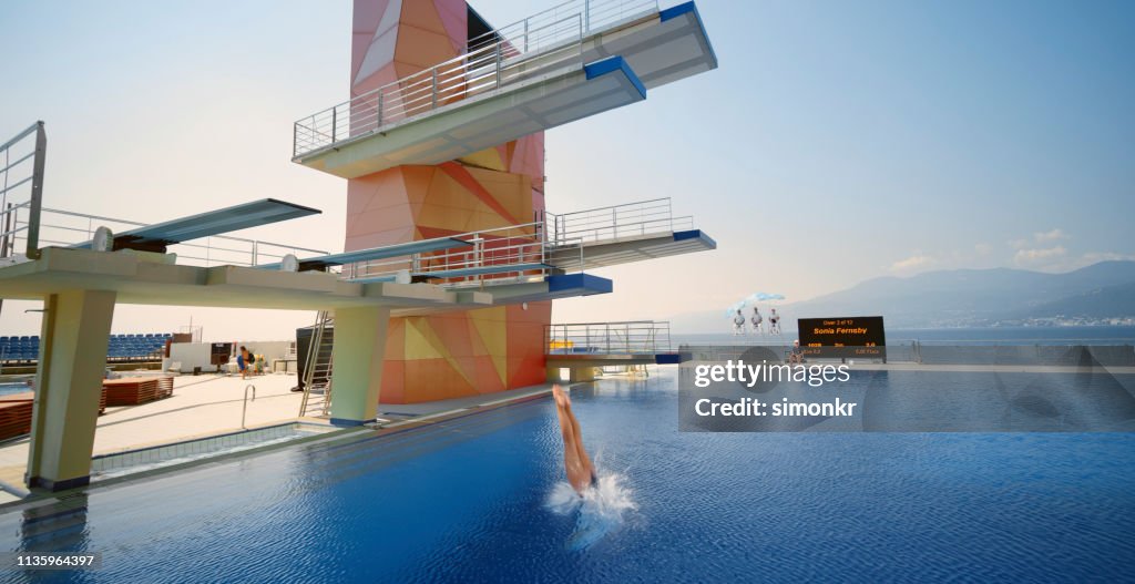 Female diver diving into swimming pool