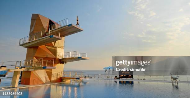 male diver in handstand position on diving board - diving platform stock pictures, royalty-free photos & images