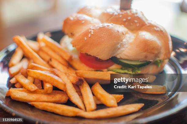 burger and fries on a wooden dining table in the restaurant - french fries top view stock pictures, royalty-free photos & images