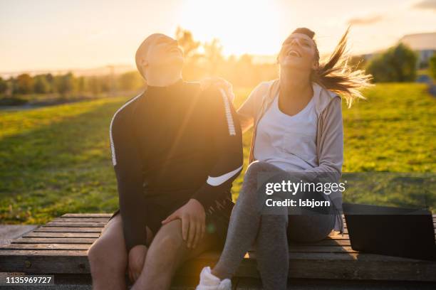 happy young couple having fun in public park. - park dusk stock pictures, royalty-free photos & images