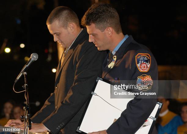 New York City Firefighter Bobby Senn comforts Chris Howard at the The 9/11 United In Memory Quilt Unveiling and Ceremony.