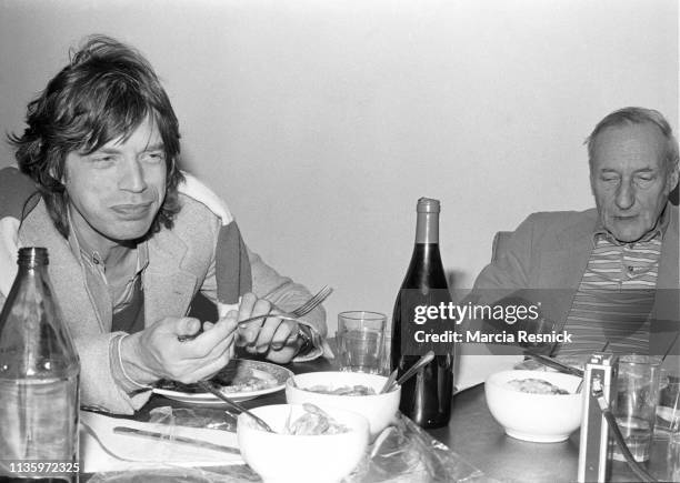 Photo of English Rock singer Mick Jagger and American Beat author William S Burroughs as they dine together at the latter's Bunker on the Bowery, New...