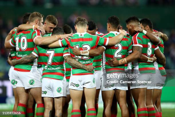 Rabbitohs players huddle and observe a minutes silence during the round one NRL match between the Sydney Roosters and the South Sydney Rabbitohs at...