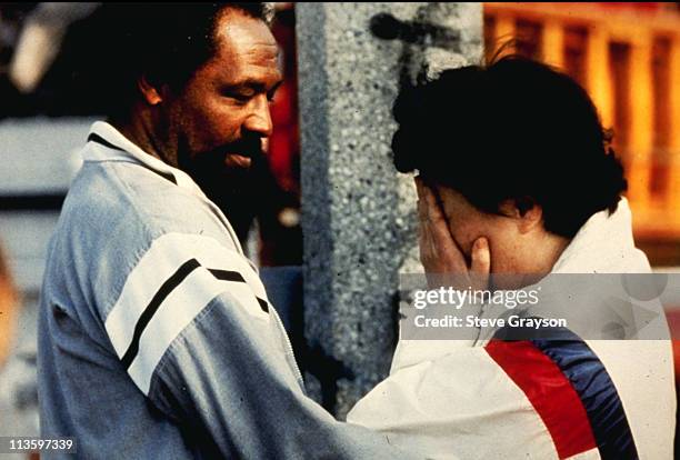 Korean store owner is comforted by a local resident after she returned to find her place of business looted and burned in south-central Los Angeles,...