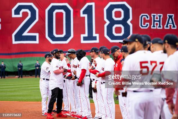 Former player Brandon Phillips of the Boston Red Sox high fives teammates during a 2018 World Series championship ring ceremony before the Opening...