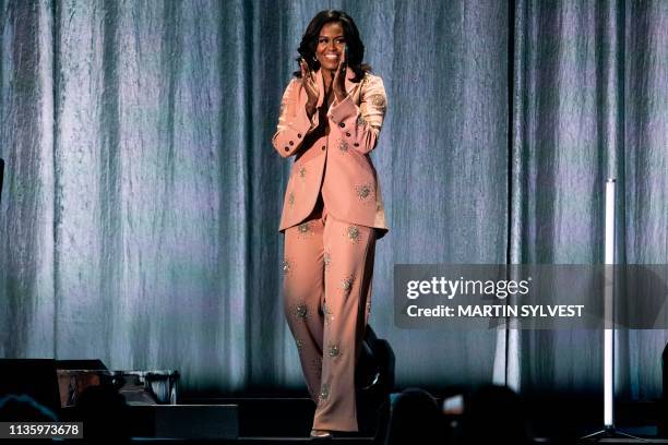 Former US first lady Michelle Obama waves on stage of the Royal Arena in Copenhagen, Denmark on April 9 during a tour to promote her memoir,...