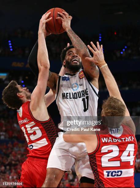 Kennedy of United drives to the basket against Clint Steindl and Jesse Wagstaff during game three of the NBL Grand Final Series between the Perth...