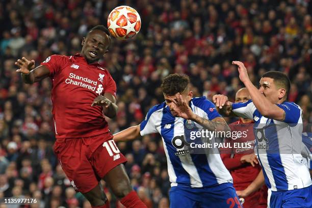 Liverpool's Senegalese striker Sadio Mane wins a header from Porto's Brazilian striker Francisco Soares and Porto's Uruguayan defender Maxi Pereira...