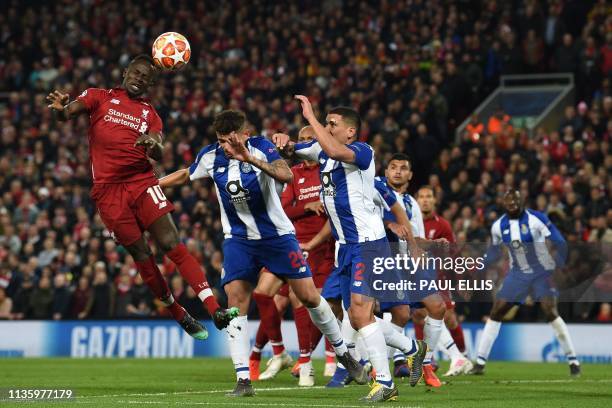 Liverpool's Senegalese striker Sadio Mane wins a header from Porto's Brazilian striker Francisco Soares and Porto's Uruguayan defender Maxi Pereira...