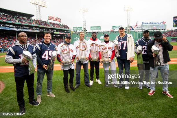 Members of the Boston Red Sox and members of the New England Patriots pose with the World Series trophies and Vince Lombardi trophies during a 2018...