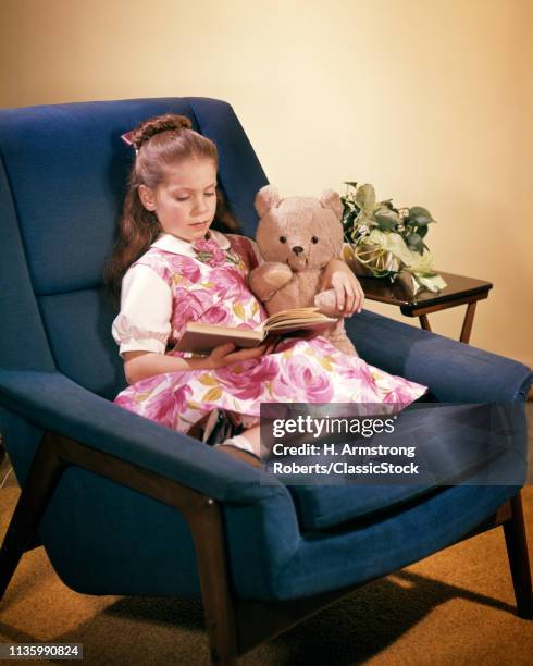 1960s GIRL & TEDDY BEAR NAVY BLUE EASY CHAIR READING A BOOK WEARING PINK WHITE FLORAL DRESS HOUSEPLANT ON END TABLE