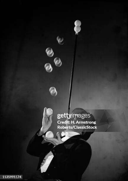 1950s PERFORMER WEARING TOP HAT & TAILS THROWING TENNIS BALLS TO SIT ON TOP OF WAND BALANCED ON CHIN