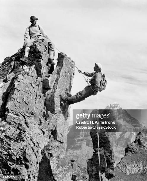 1950s 1960s TWO ANONYMOUS MEN ROCK CLIMBERS SCALING SWISS MOUNTAIN OUTCROP