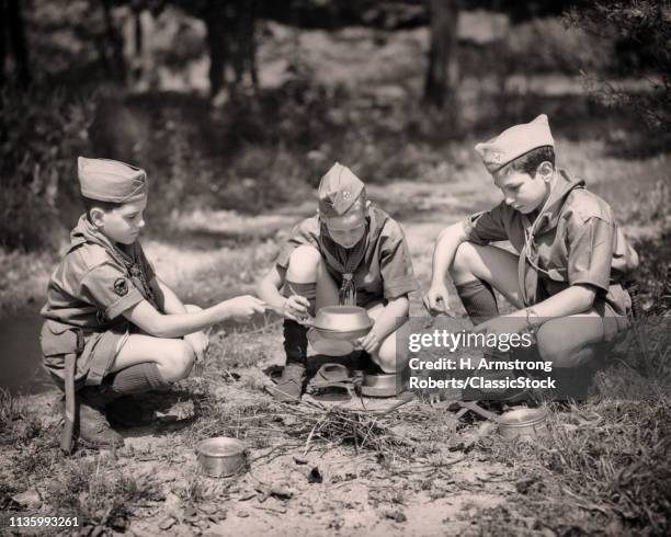 1950s THREE BOYS SCOUTS COOKING OVER CAMPFIRE