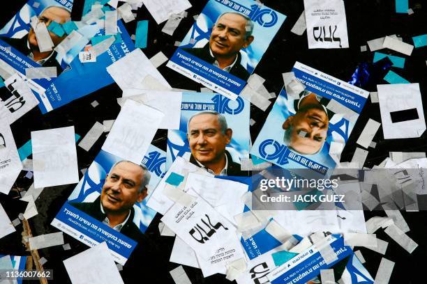 This picture taken early on April 10, 2019 shows Israeli Likud Party campaign material and posters of Prime Minister Benjamin Netanyahu strown on the...