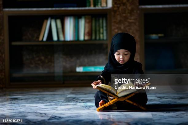 asian indonesian muslim kid is reading the holy quran. - islamic kids fotografías e imágenes de stock
