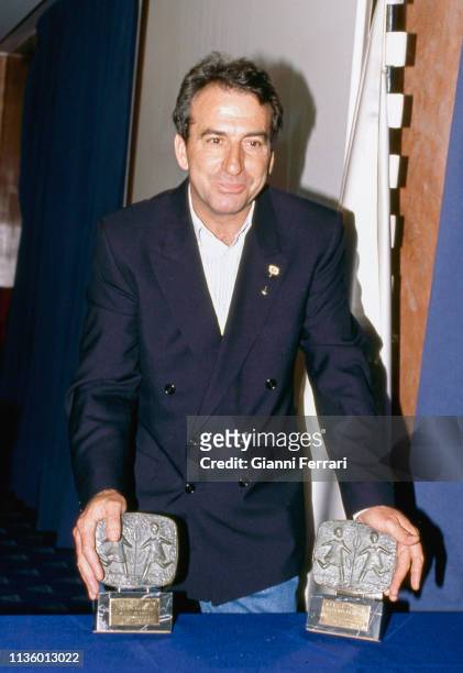 Portrait of Spanish singer Jose Luis Perales as he poses with two unspecified awards, Madrid, Spain, 1992.