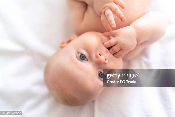 pequeño bebé lindo en la cama - mouth fotografías e imágenes de stock