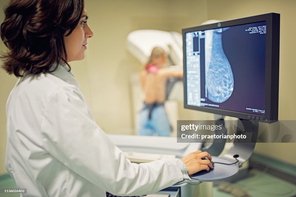 Doctor is working with mammography X-ray scanner in hospital