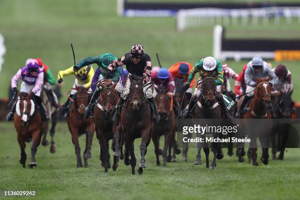 Harry Skelton celebrates winning the The Randox Health County Handicap Hurdle Race with horse Ch'tibello ahead of Daryl Jacob and horse We Have A...