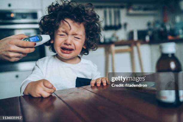 measuring little boy's temperature - baby ear infection stock pictures, royalty-free photos & images
