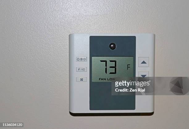 indoor digital thermostat on a wall set at 73 degrees fahrenheit - fahrenheit imagens e fotografias de stock